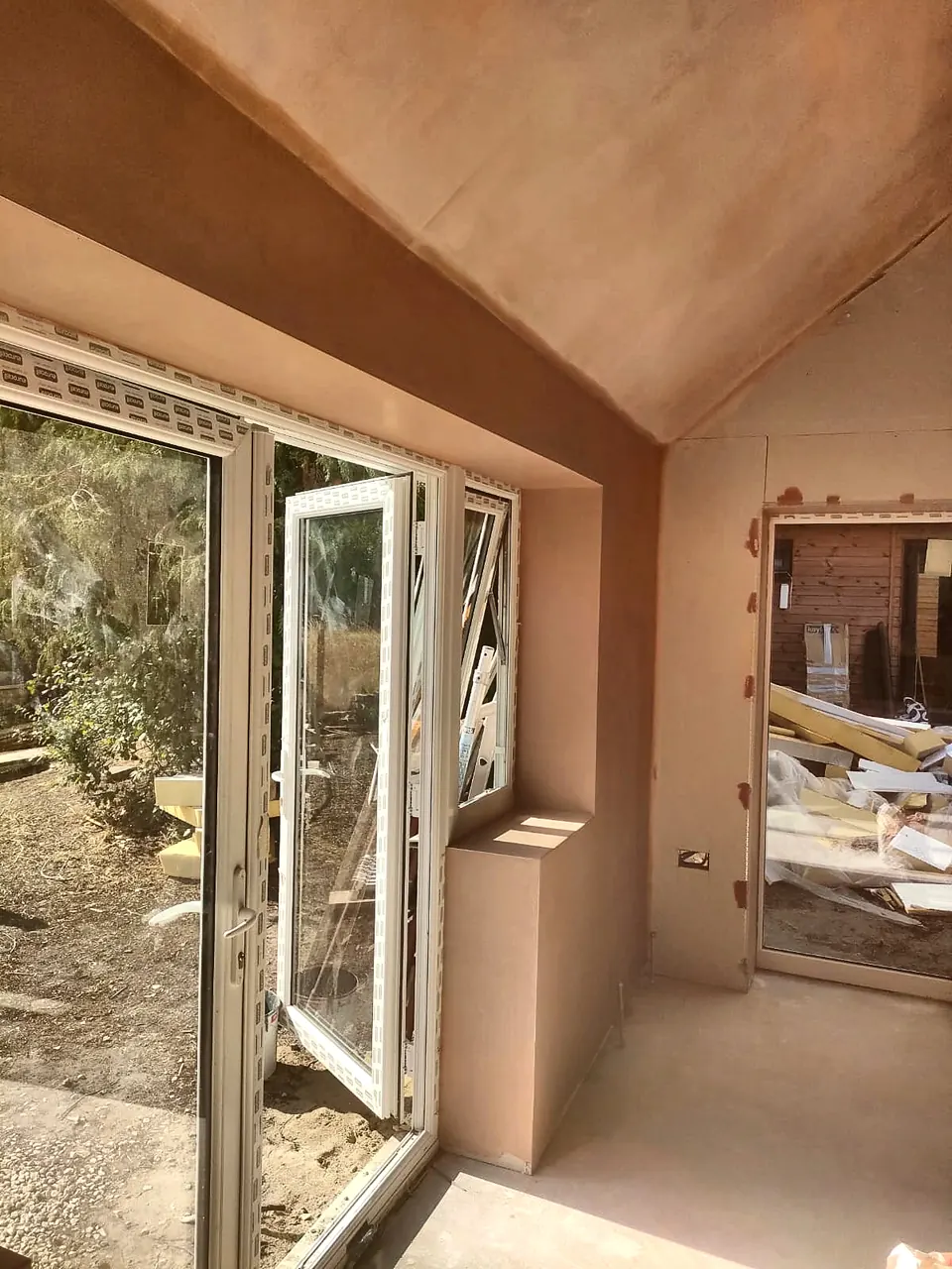 Newly plastered room with glazed doors opening to the garden