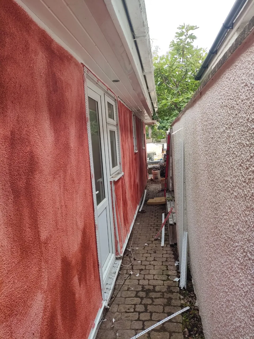 Side wall of a bungalow with white render beads fitted and the wall prepared for render